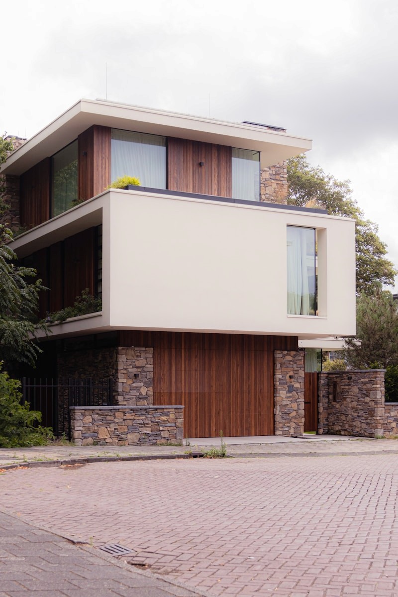 Zurückhaltendes Wohnhaus mit Holz, Stein und großzügigen Fenstern
